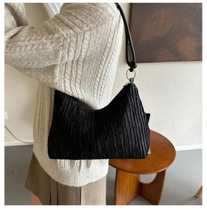 Détail du sac hobo en tissu plissé noir avec anneau métallique et bandoulière chic