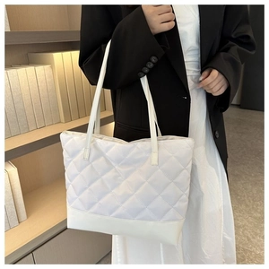 Dettaglio borsa shopper bianca trapuntata con fondo rinforzato e spalline sottili in pelle