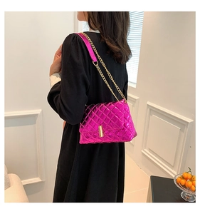 Macro detail of quilted fuchsia metallic leather handbag with gold chain strap
