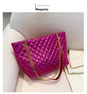 Detail of rose red metallic quilted tote bag with golden chain on white sofa