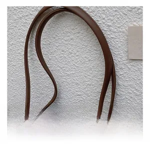 Detail of comfortable brown leather tote bag strap showing neat stitching and smooth texture