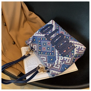Detail of vintage ethnic woven tote bag with blue leather handles and gold metal rings