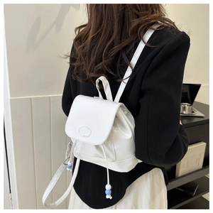 Detailansicht eines weißen Mini-Rucksacks mit Kordelzug und blauen Zierperlen