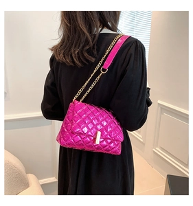 Close-up of pink quilted chain bag with metallic finish and gold lock on a model