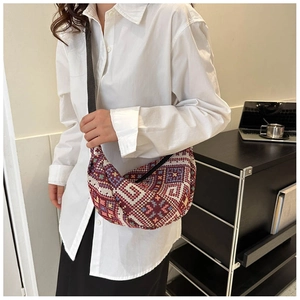 Close-up of geometric ethnic woven patterned handbag with adjustable black strap