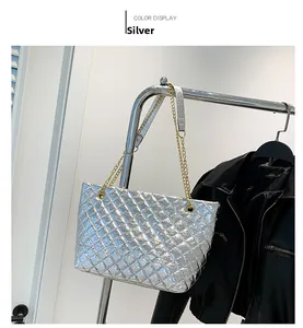 Detail view of silver quilted tote bag featuring metallic finish and gold chain strap