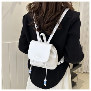 Detailansicht des weißen Mini-Rucksacks mit Klappenverschluss und blauem Perlenzug