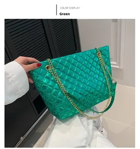 Close-up of green metallic quilted tote bag with golden chain straps and glossy finish
