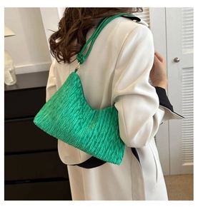 Détail de la texture plissée d'un sac cabas vert vif avec finitions en métal argenté