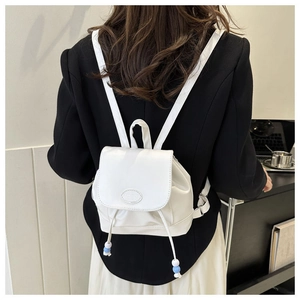 Details des weißen Nylon-Minirucksacks mit Kordelzug und blauen Perlen am Modell präsentiert