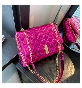 Detail of rose red quilted crossbody bag with gold chain strap and metallic texture