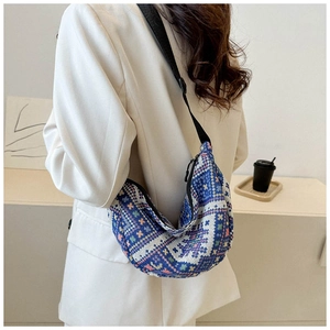Detailed close-up of a blue geometric jacquard dumpling bag with an adjustable strap