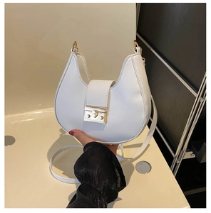 Detailed view of the white crescent hobo bag featuring a polished gold buckle and strap