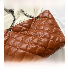 Gros plan sur le sac fourre-tout matelassé marron avec surpiqûres losanges et bandoulière chaîne