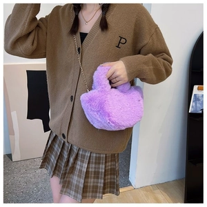 Gros plan du sac seau en peluche violette avec bandoulière chaîne dorée sur modèle