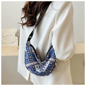 Detail of a knit half-moon crossbody bag with ethnic patterns and adjustable strap