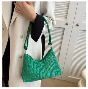 Détail du sac hobo vert vif plissé avec texture gaufrée et anneaux dorés sur la bandoulière