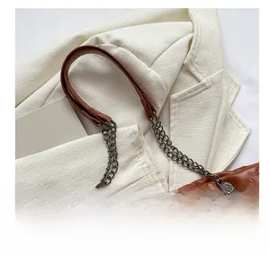Détail du sac à bandoulière marron matelassé avec chaîne en métal et épaulière en cuir