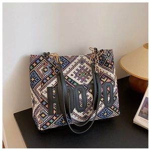 Detail of bohemian knit tote bag showing colorful geometric patterns and leather handles