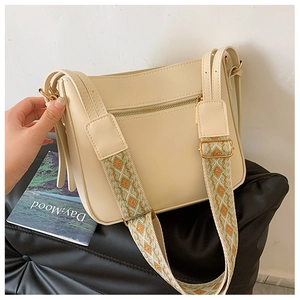 Detail of off-white crossbody bag with wide geometric ethnic pattern woven strap