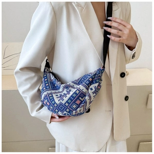 Detail view of woven geometric pattern fabric on a navy blue crescent shoulder bag