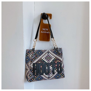 Close-up of ethnic woven tote bag featuring geometric patterns and HOOTO embroidery