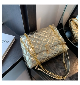 Close-up of golden quilted crossbody bag with metallic finish and chain strap