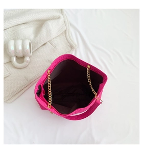 Detalle del bolso tote fucsia grande con grabado geométrico y correa de cadena dorada