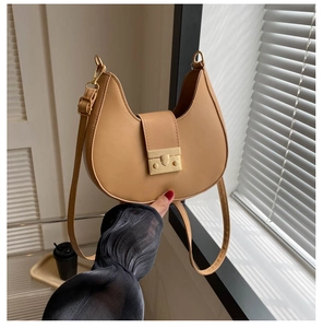 Detail of camel crescent saddle bag showing smooth leather texture and gold metal clasp