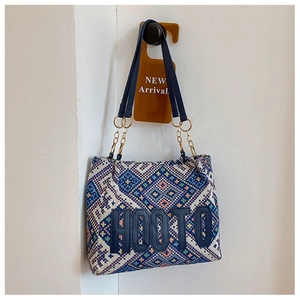 Detailed macro view of ethnic tote bag with HOOTO embroidery and gold chain strap