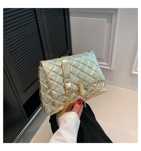 Detailed view of champagne gold quilted crossbody bag with luxury cylindrical metal lock