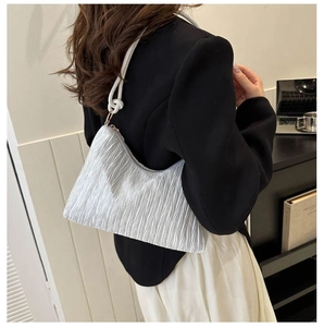 Détail du sac plissé argenté avec bandoulière en corde épaisse et anneaux dorés