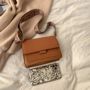 Matte leather crossbody bag with wide woven strap and stylish color-block design