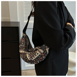 Detail of colorful geometric jacquard weaving on a crescent-shaped crossbody bag
