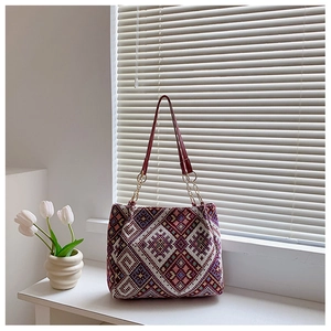 Close-up of ethnic tote bag with colorful geometric patterns and elegant chain handle detail