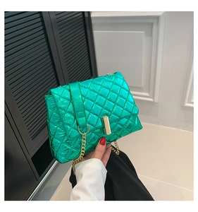 Close-up of bright green quilted handbag with metallic finish and gold chain strap