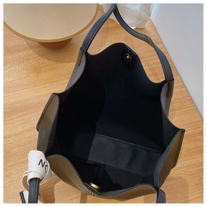 Top view of spacious black tote bag interior showing magnetic clasp and ribbon detail