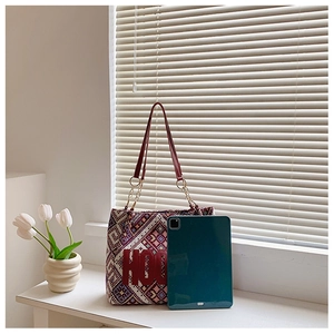 Close-up of ethnic tote bag with geometric embroidery, HOO patch, and leather chain straps
