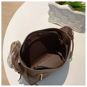 Internal view of brown leather bag with large main compartment and ethnic woven strap