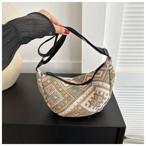 Detail of jacquard woven half-moon bag with colorful geometric patterns and adjustable strap