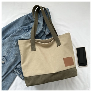 Vista dettagliata di una borsa tote in tela con manici verde oliva e tessuto kaki
