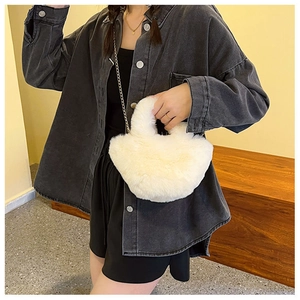 Détail du sac seau en peluche blanche avec bandoulière chaîne et veste denim