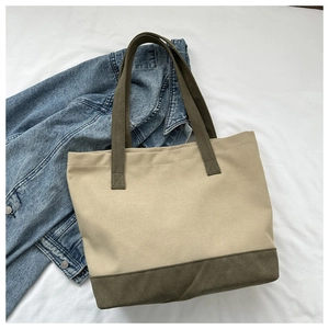Dettaglio cuciture rinforzate a X sulla borsa tote in tela beige con manici a contrasto verdi