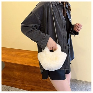 Détail de texture du mini sac seau en fausse fourrure blanche avec chaîne en métal
