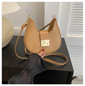 Detail of khaki crescent shoulder bag with golden buckle and adjustable leather strap