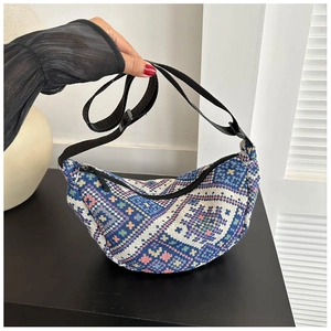 Detail view of the bohemian geometric woven texture on this dumpling-style shoulder bag