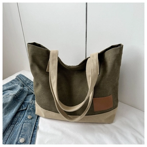 Dettaglio della borsa tote in tela con patchwork verde oliva e beige e logo in pelle
