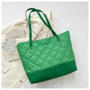 Dettaglio della borsa tote trapuntata verde con base rinforzata e cuciture a rombi