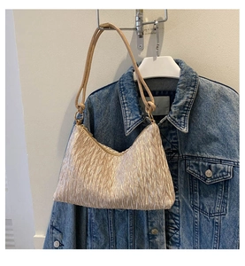 Gros plan du sac hobo plissé or champagne avec finition satinée et bandoulière fine