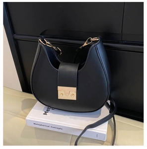 Detailed view of black crescent leather shoulder bag with elegant golden square clasp buckle